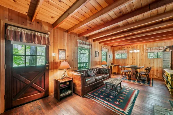 a living room with furniture a wooden floor and next to a window