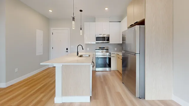 a kitchen with kitchen island a sink appliances and cabinets