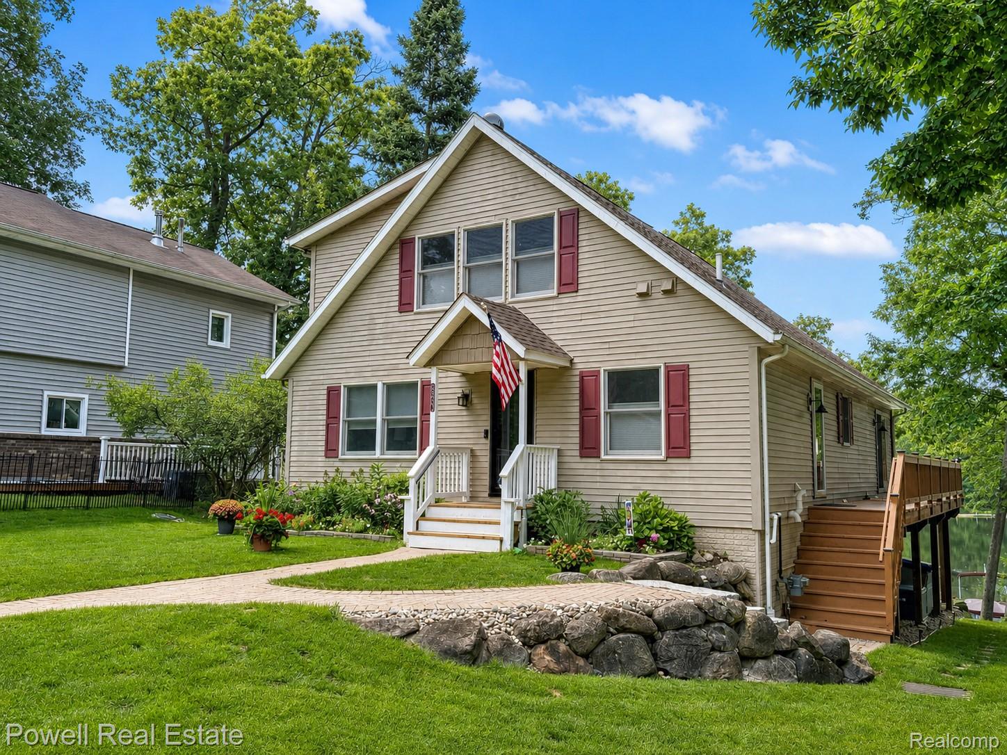 6807 Big Trail Road Holly, MI 48442 - Photo 1 of 45 Siding exterior featuring a front entry with white railings, red window shutters, and a multi-level deck