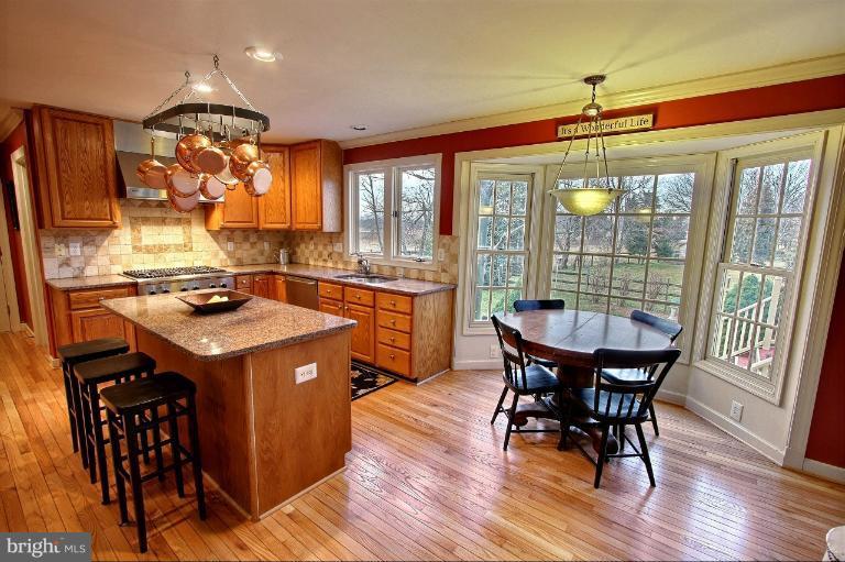 20003 Hickman Way Poolesville, MD 20837 - Photo 27 of 30 a kitchen that has a stove a table and chairs in it
