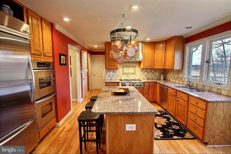 20003 Hickman Way Poolesville, MD 20837 - Photo 5 of 30 a kitchen with stainless steel appliances granite countertop a sink a stove and a refrigerator