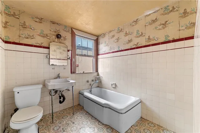 a white toilet sitting next to a bathroom sink