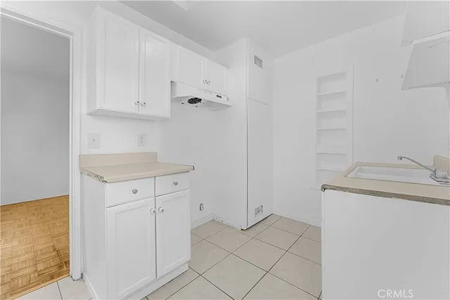 a kitchen with white cabinets and a sink