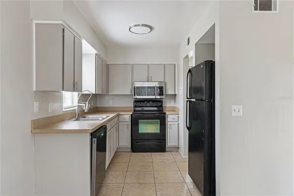 a kitchen with a refrigerator sink and stove top oven