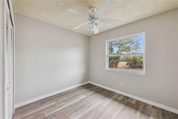 an empty room with a window and a ceiling fan