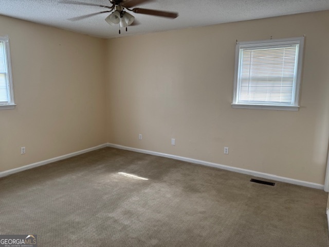 317 Emory Drive Warner Robins, GA 31093 - Photo 23 of 28 an empty room with a ceiling fan and a window