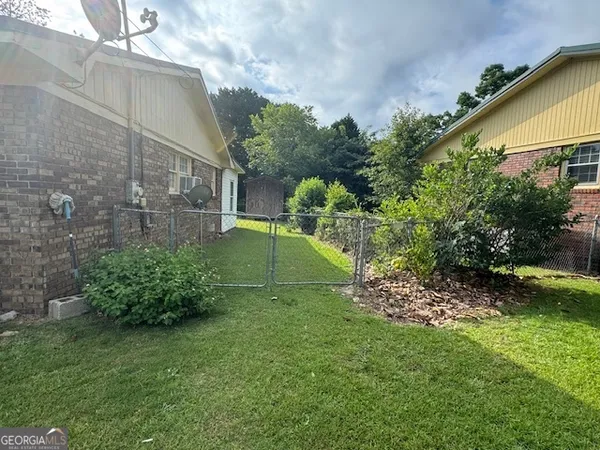 a front view of house with yard and trees in the background