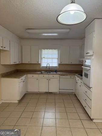 a large white kitchen with cabinets