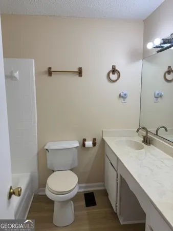 a bathroom with a granite countertop toilet sink and mirror