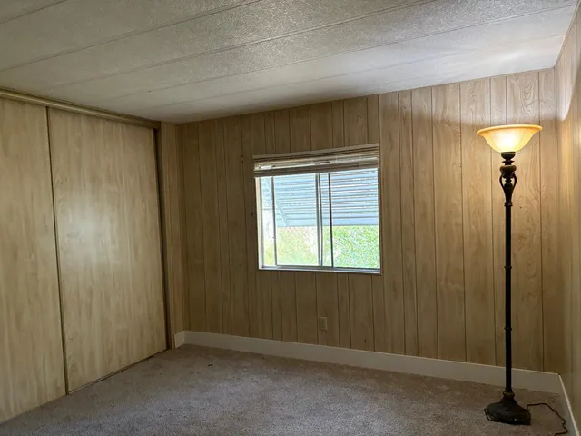 a view of an empty room with window and a bathroom