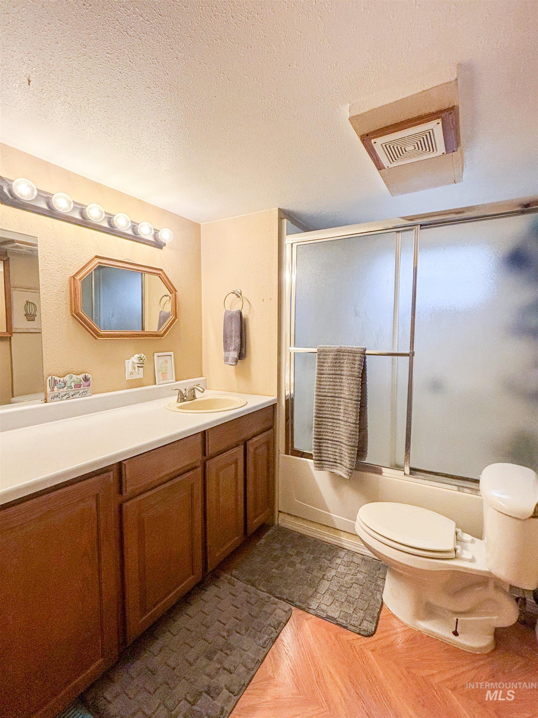 2280 Old Pullman Road, Unit 20 Moscow, ID 83843 - Photo 13 of 20 Full bath with a textured ceiling, vanity, and bath / shower combo with glass door