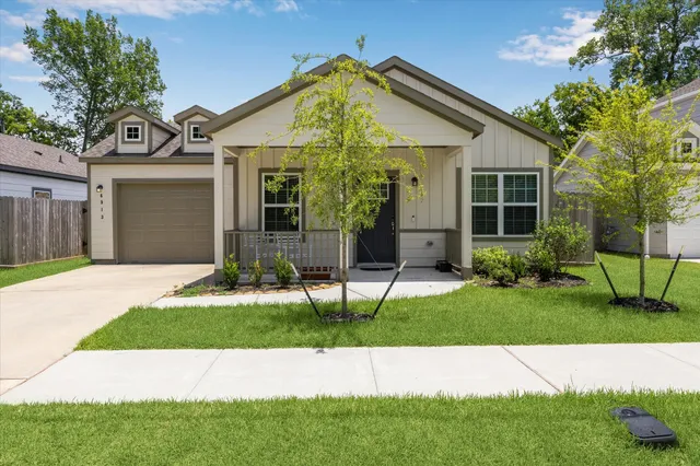 a front view of a house with a garden and yard