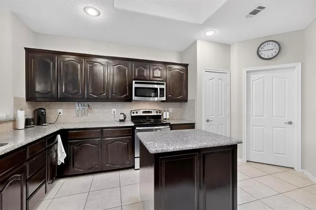 a kitchen with stainless steel appliances granite countertop a stove top oven a sink and dishwasher