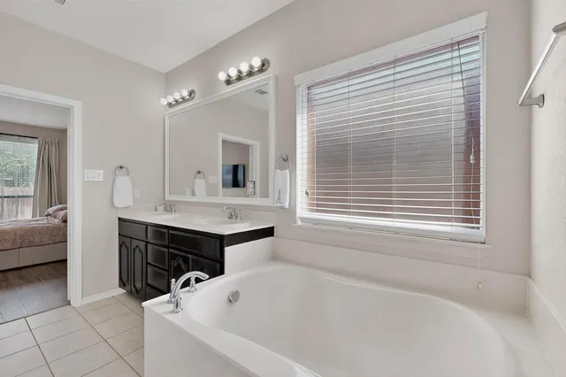 a bathroom with a tub sink and mirror