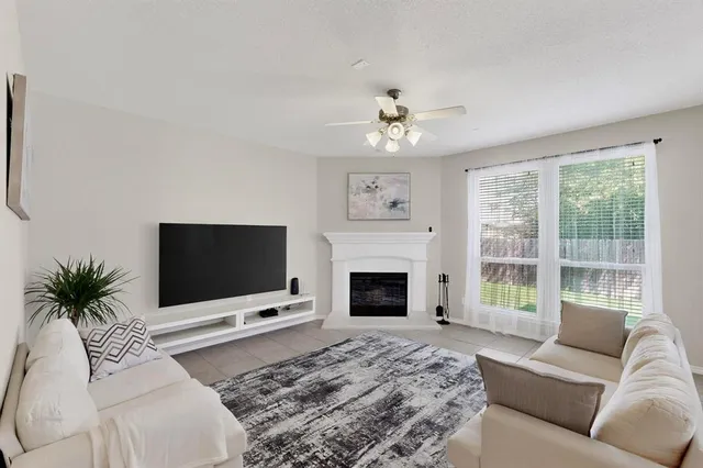 a living room with furniture a flat screen tv and a fireplace