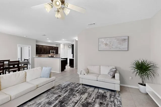 a living room with furniture and a large mirror with wooden floor