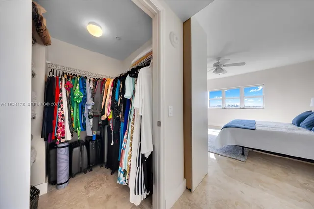 a view of walk in closet with clothes and shoes