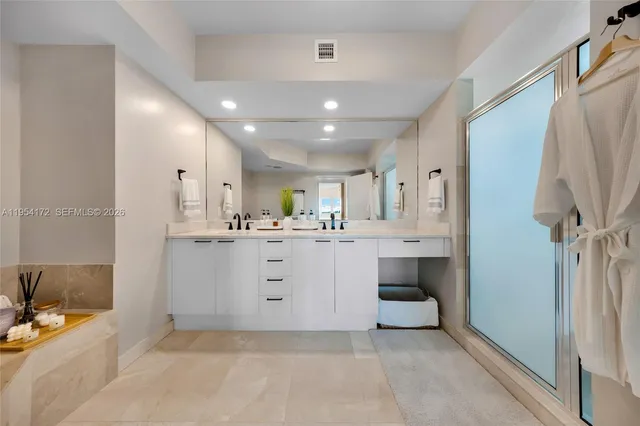 a large white kitchen with a sink stainless steel appliances and cabinets