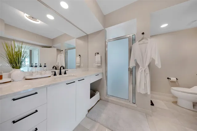 a bathroom with a double vanity sink toilet and shower