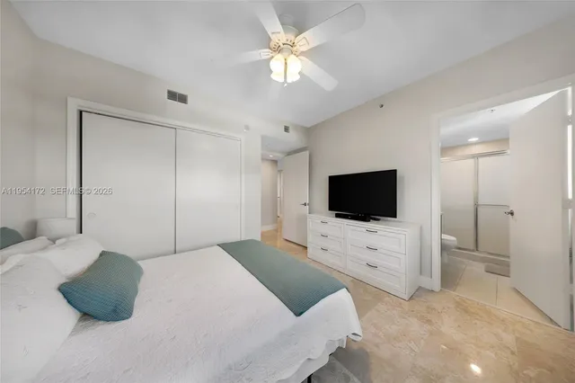 a bedroom with a bed flat screen tv and a couch