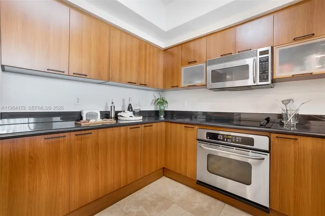 a kitchen with stainless steel appliances wooden cabinets and a stove top oven