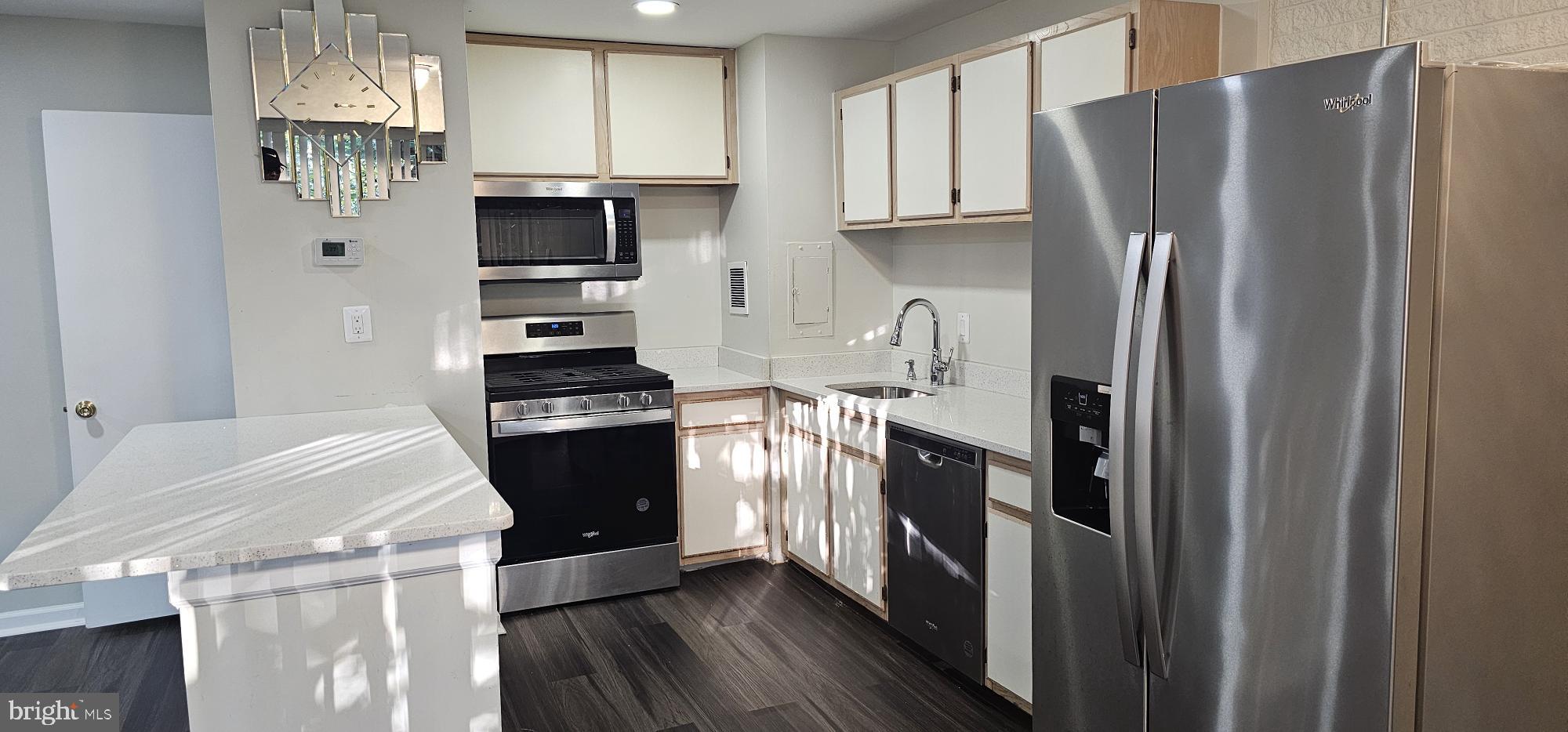 1802 Metzerott Road, Unit 503 Silver Spring, MD 20903 - Photo 4 of 11 a kitchen with a refrigerator and a stove top oven