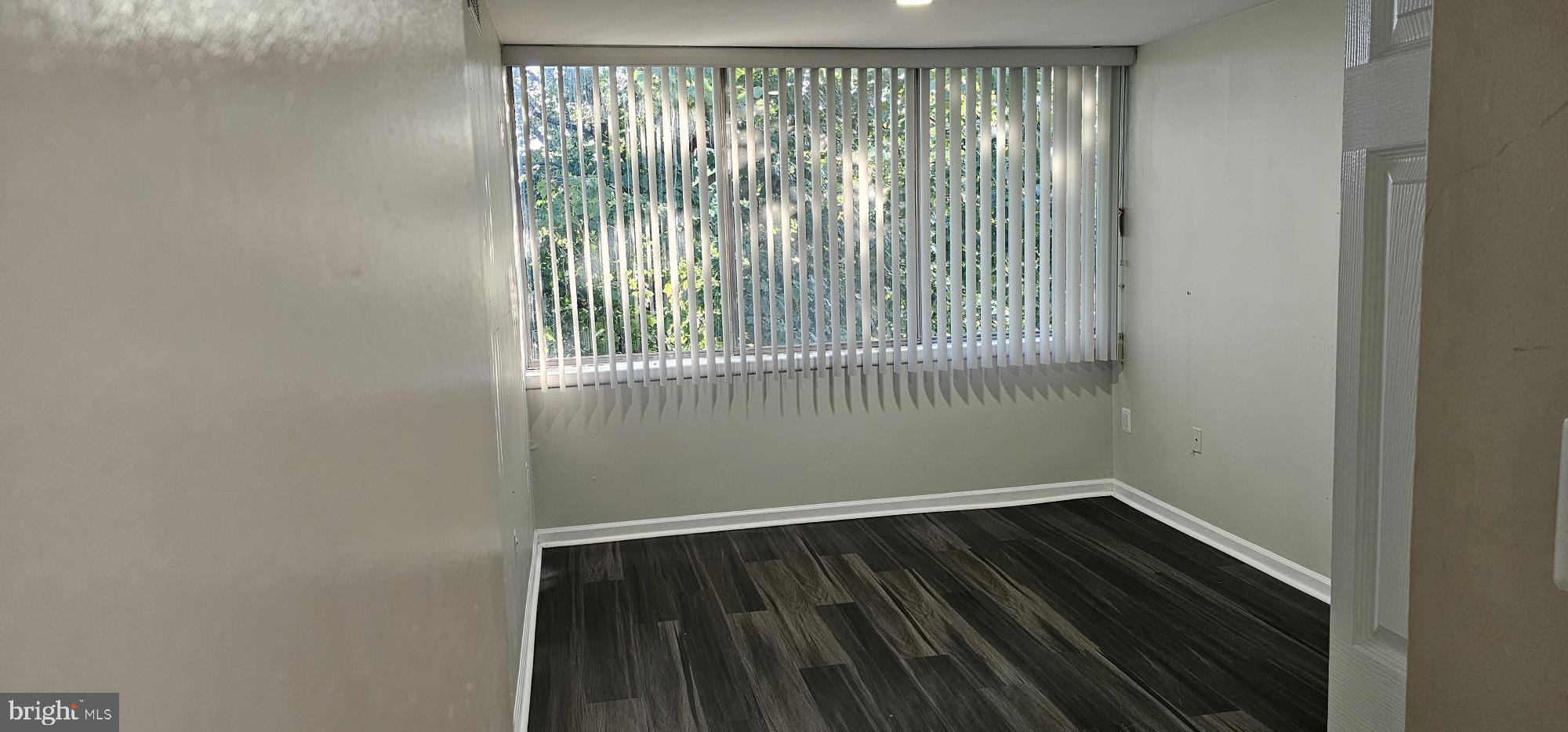 1802 Metzerott Road, Unit 503 Silver Spring, MD 20903 - Photo 8 of 11 a view of an empty room with wooden floor and a window