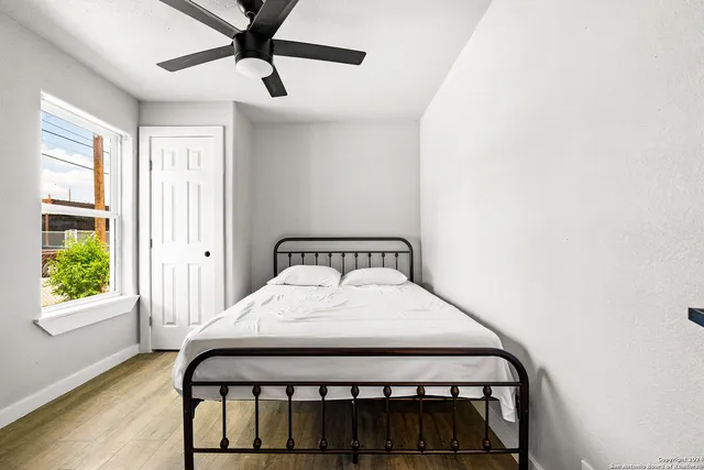a bedroom with a bed window and a chandelier