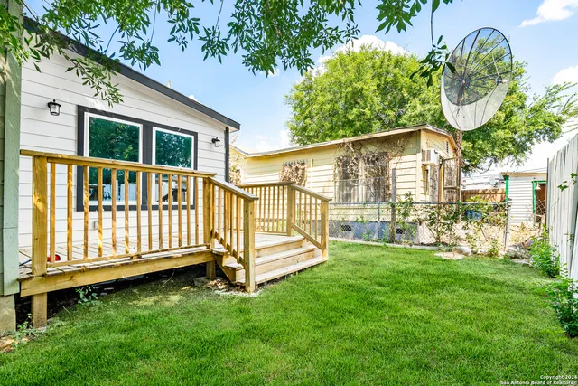a view of an house with backyard and deck