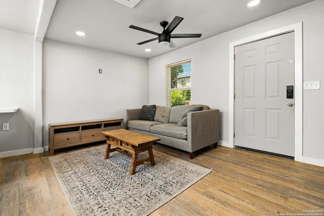 a living room with furniture and a wooden floor