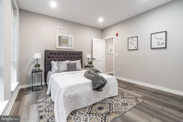 a kitchen with stainless steel appliances a refrigerator a sink and wooden floor