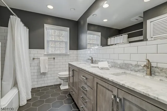a bathroom with a double vanity sink mirror and toilet