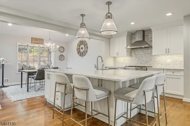 a kitchen with stainless steel appliances kitchen island granite countertop a table chairs and a refrigerator