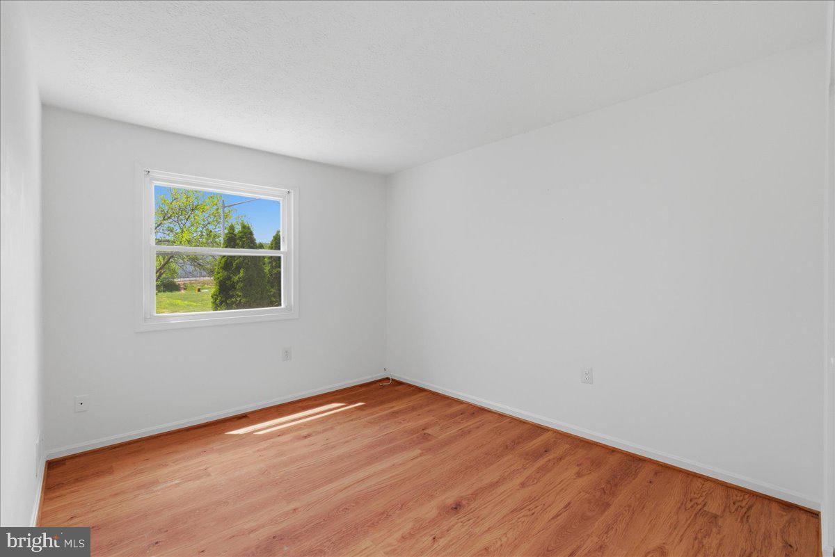 10177 Irongate Way Manassas, VA 20109 - Photo 12 of 28 a view of empty room with wooden floor and fan