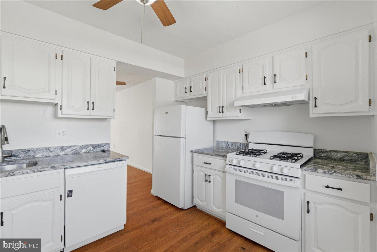 10177 Irongate Way Manassas, VA 20109 - Photo 17 of 28 a kitchen with cabinets appliances a sink and wooden floor