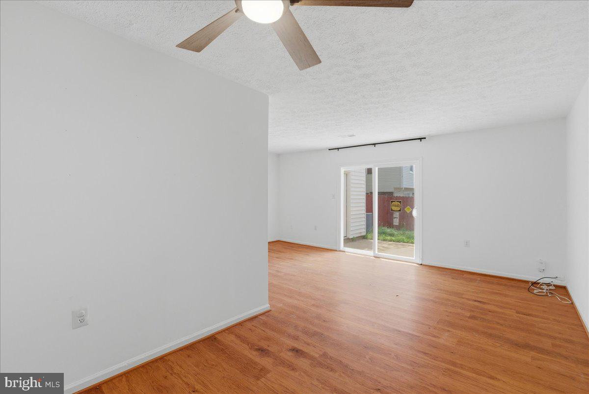 10177 Irongate Way Manassas, VA 20109 - Photo 23 of 28 an empty room with wooden floor chandelier fan and windows