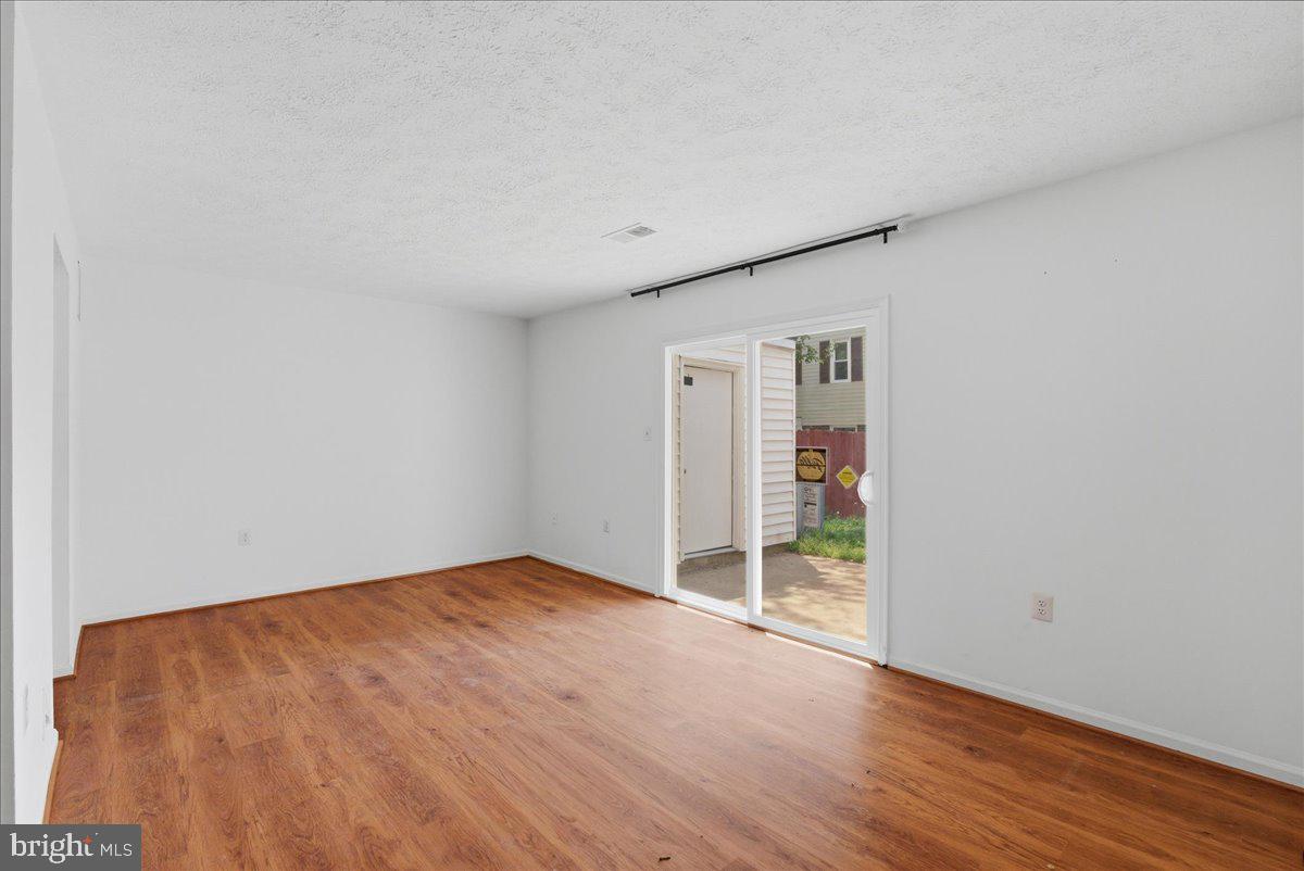 10177 Irongate Way Manassas, VA 20109 - Photo 6 of 28 a view of an empty room with wooden floor