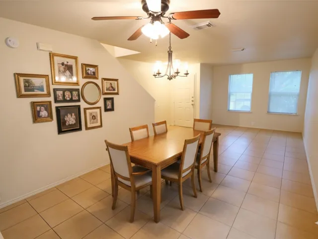 a view of a dining room with furniture and chandelier fan