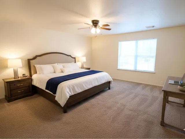 a spacious bedroom with a bed and a chandelier