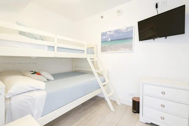 a bedroom with a bed and flat screen tv