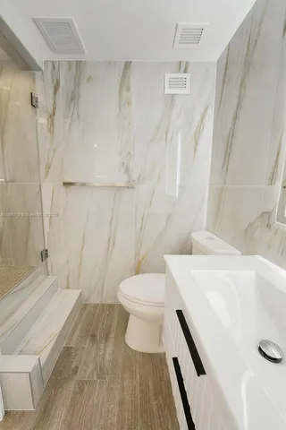 a bathroom with a sink a toilet and shower