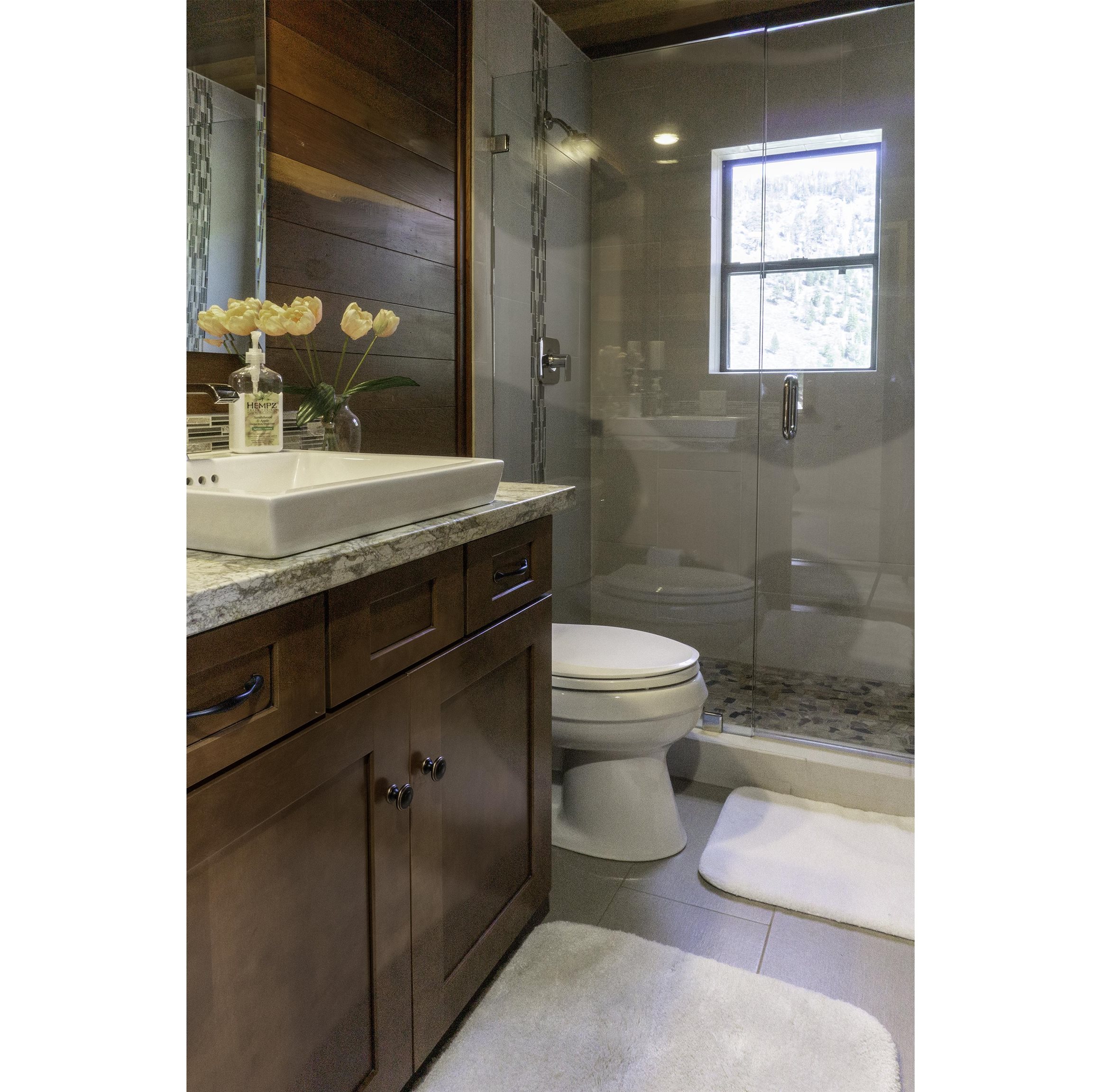 214 Skyline Road June Lake, CA 93529 - Photo 17 of 39 a bathroom with a granite countertop toilet a sink and shower