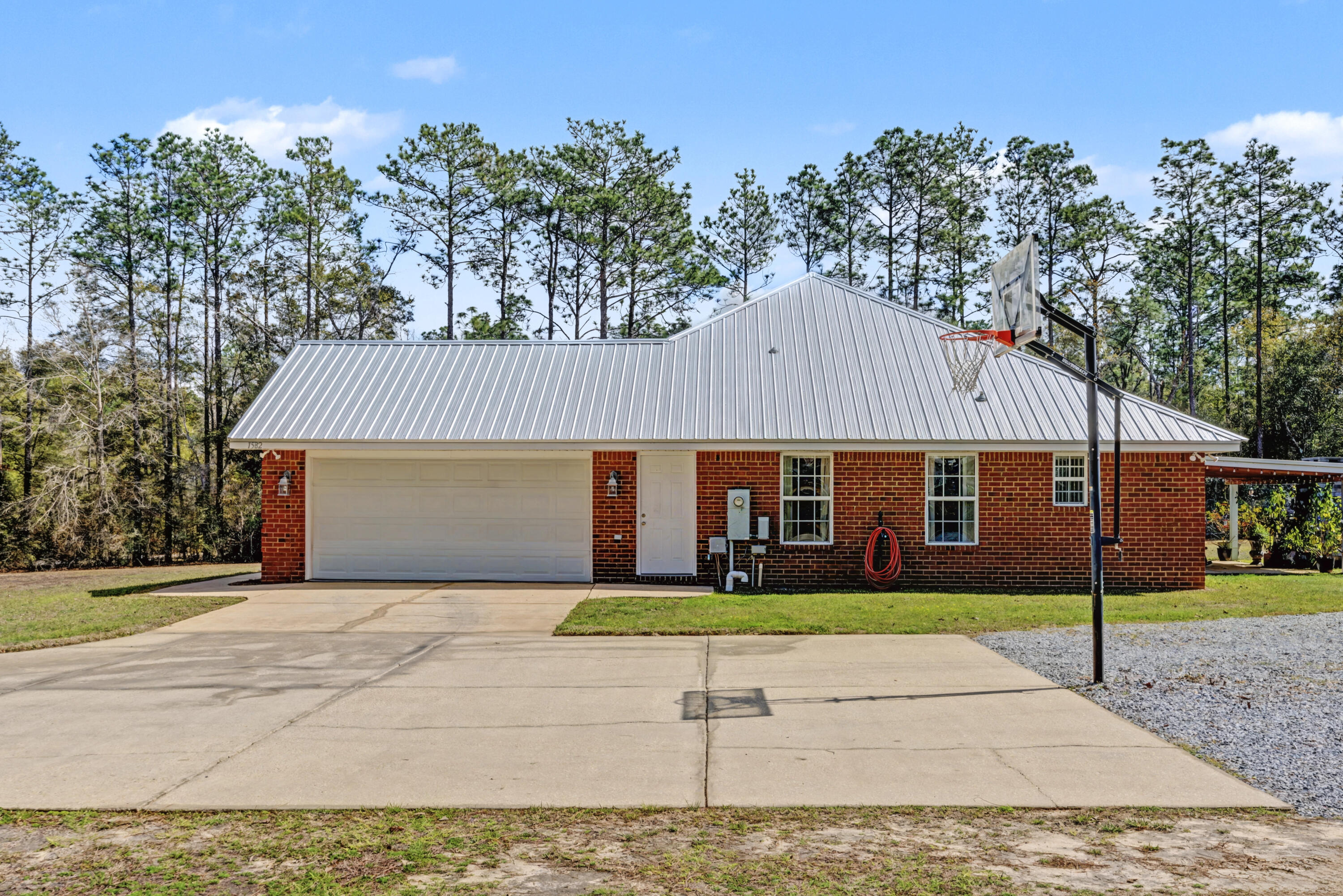 1582 Greenwood Road Baker, FL 32531 - Photo 30 of 49 a front view of a house with a garden and trees