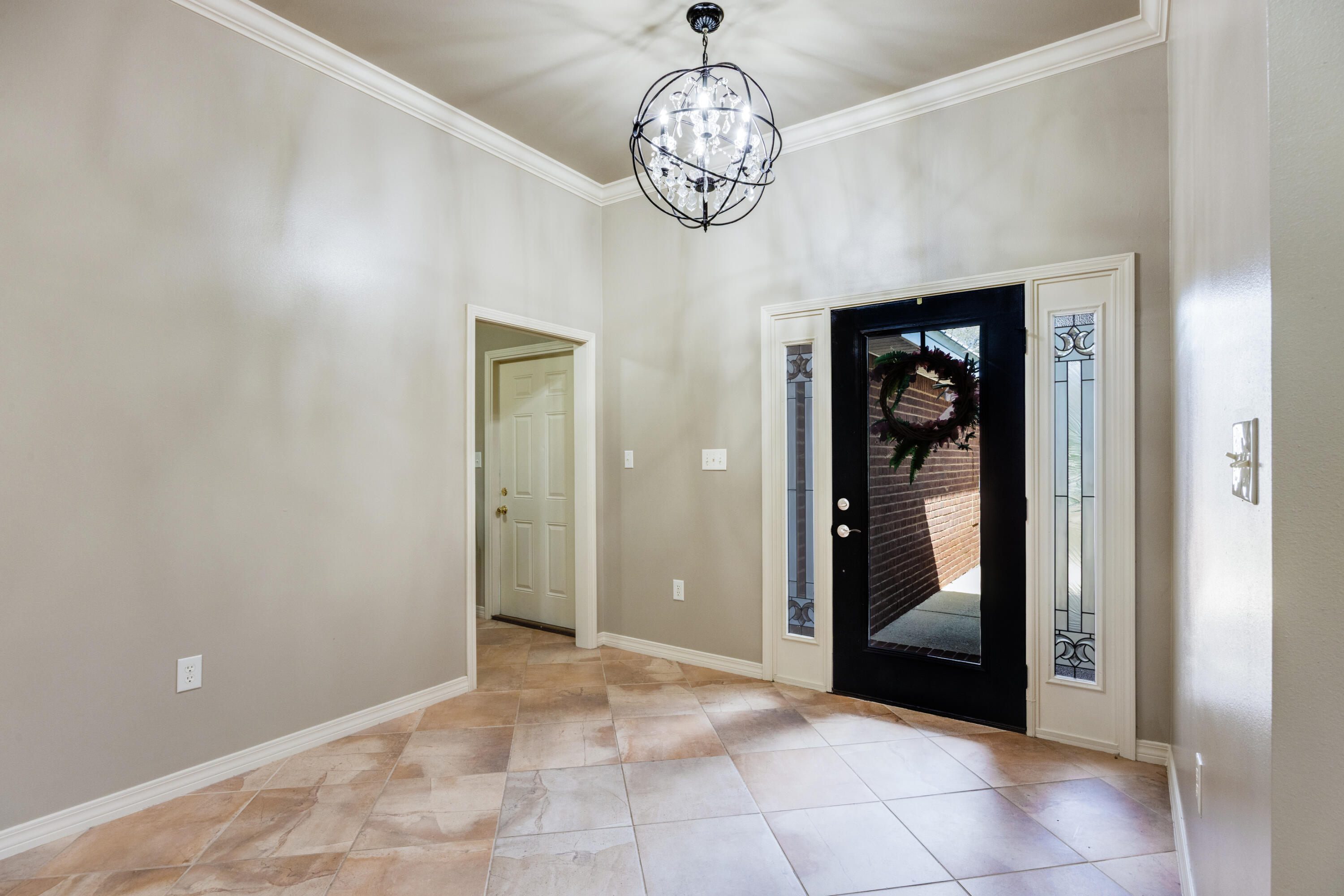 1582 Greenwood Road Baker, FL 32531 - Photo 6 of 49 a view of a hallway with wooden floor and a chandelier