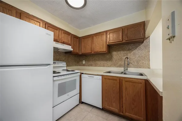 a kitchen with a sink cabinets stainless steel appliances and a window