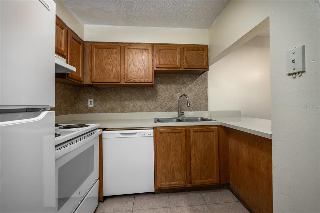 6519 West Newberry Road, Unit 1004 Gainesville, FL 32605 - Photo 10 of 17 a kitchen with stainless steel appliances granite countertop a sink and a stove