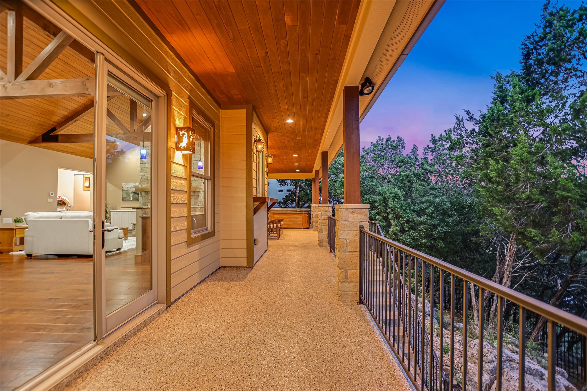 409 Venture Boulevard South Point Venture, TX 78645 - Photo 23 of 37 Expansive covered balcony featuring a textured flooring surface, stone and metal railings, and wood-paneled ceilings