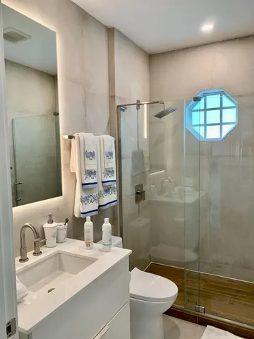 a bathroom with a sink a toilet and shower
