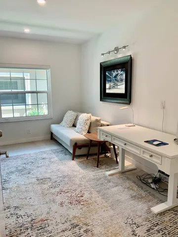 a living room with furniture a rug and a window
