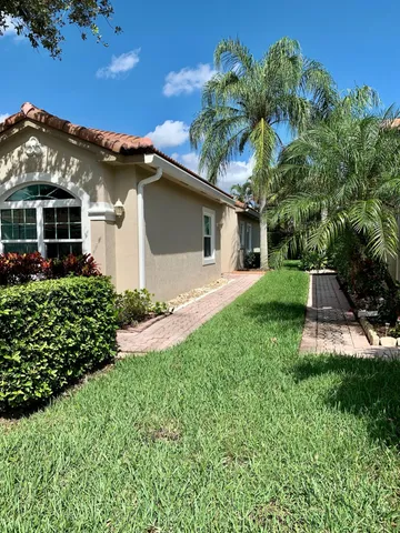 a front view of a house with a yard and potted plants